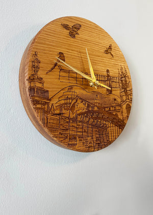 Side view of handmade solid oak laser engraved clock. Featuring landmarks such as St James' Park, Greys Monument, The Glasshouse, Newcastle Cathedral, The Tyne Bridge, Angel of the North and Newcastle Cathedral. 